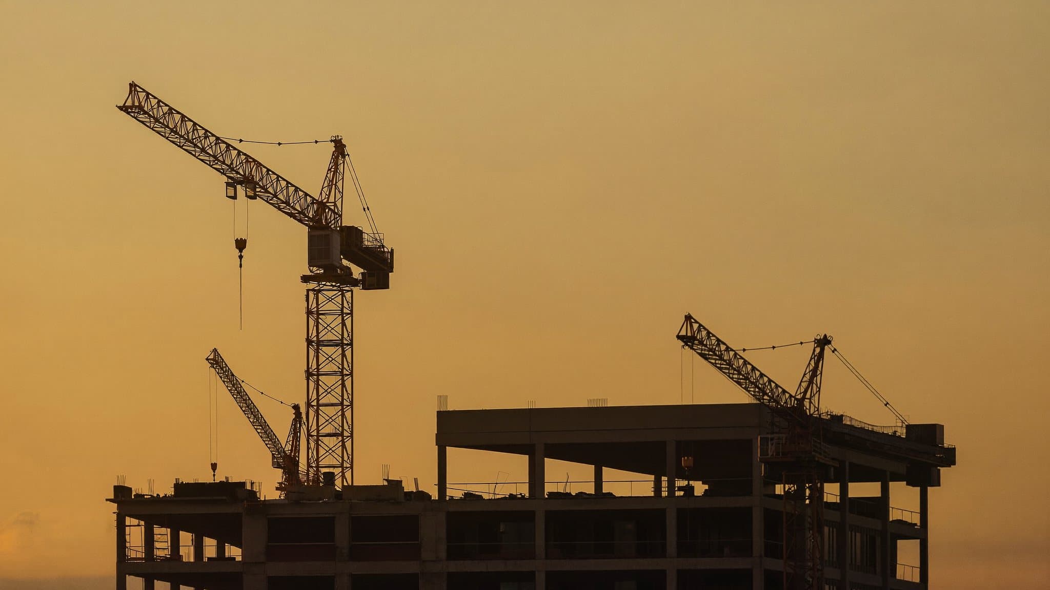 Grues de chantier à l’heure dorée — la promotion immobilière en action